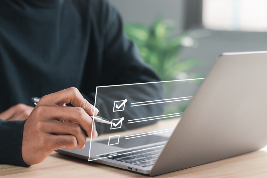 Image of laptop on desk with a checkbox illustration hovering.