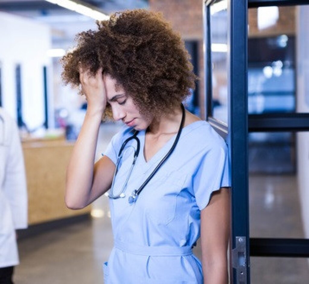 nurse holding her head.