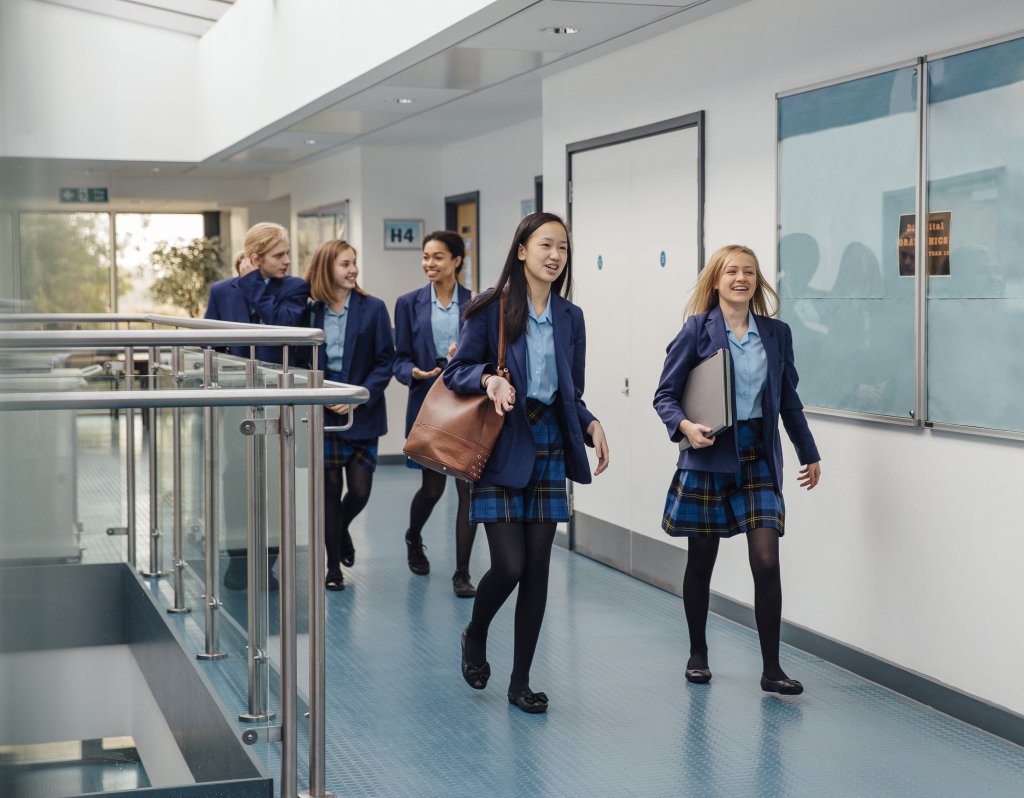 Students walking along a corridor in a school.