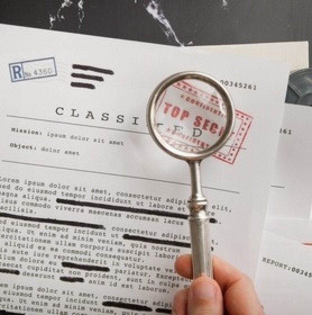 A document stating classified, and a magnifying glass highlighting a top secret stamp.