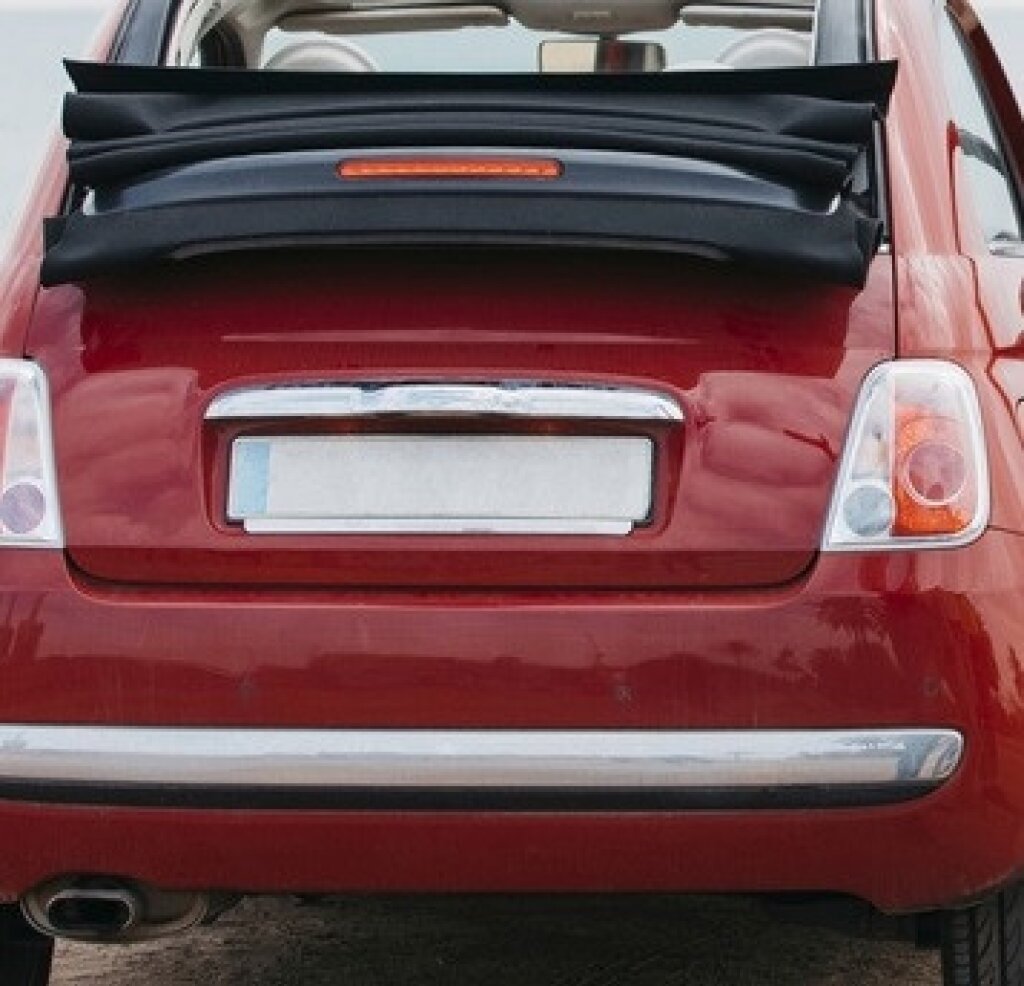 Why should you blur out license plates in videos? The rear of a red car with its license plate blurred.