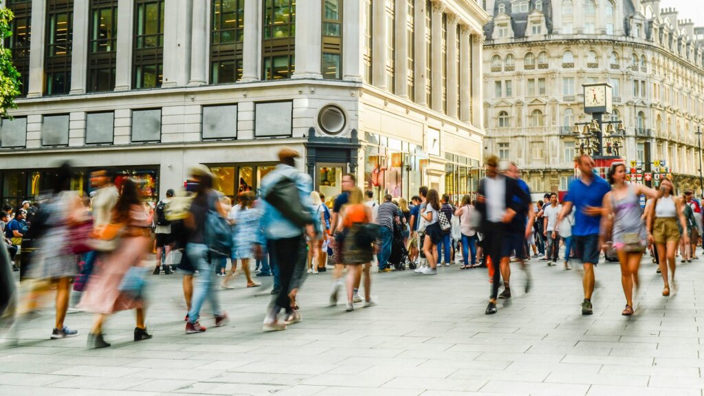 Long exposure photograph of people walking through a busy pedestrian area.