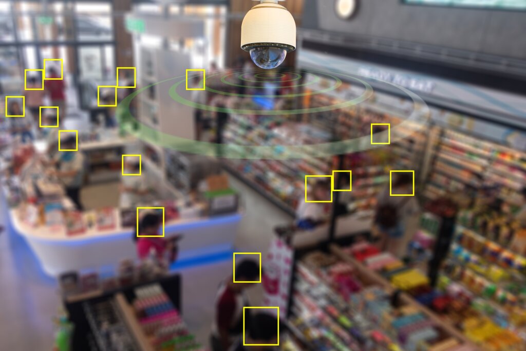 A store which is blurred in the background, a CCTV dome camera in the foreground and yellow squares highlighting where heads are.