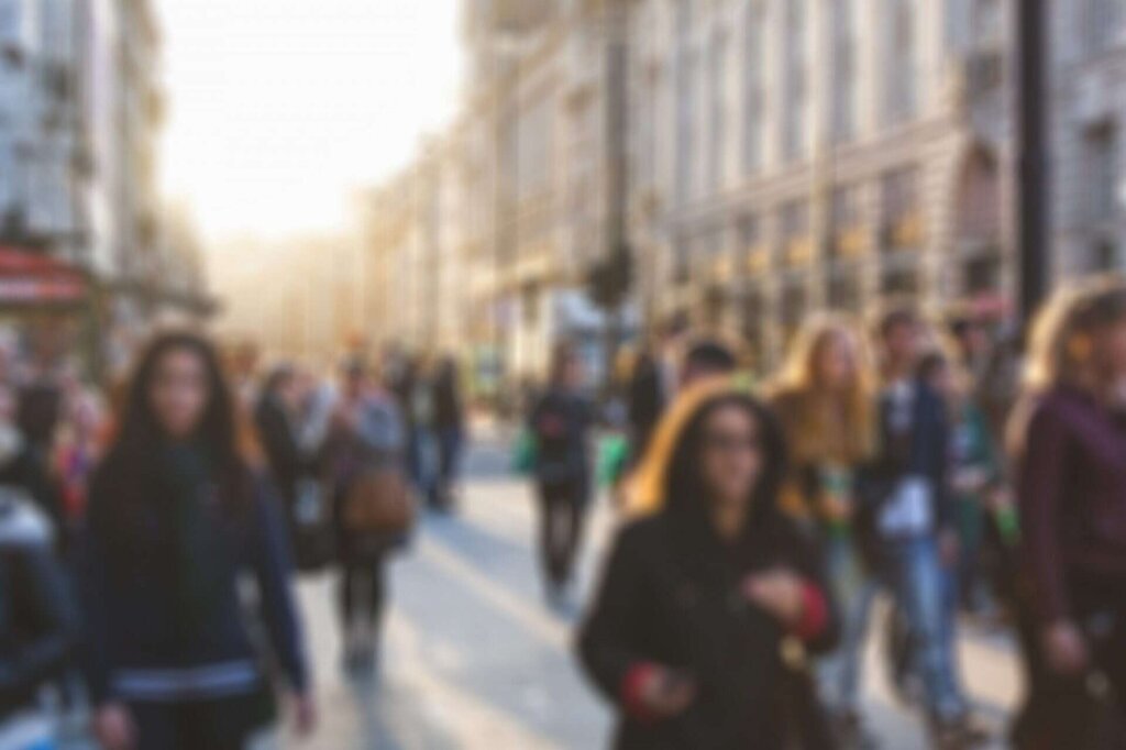 Blurred photo of people walking in a busy street.